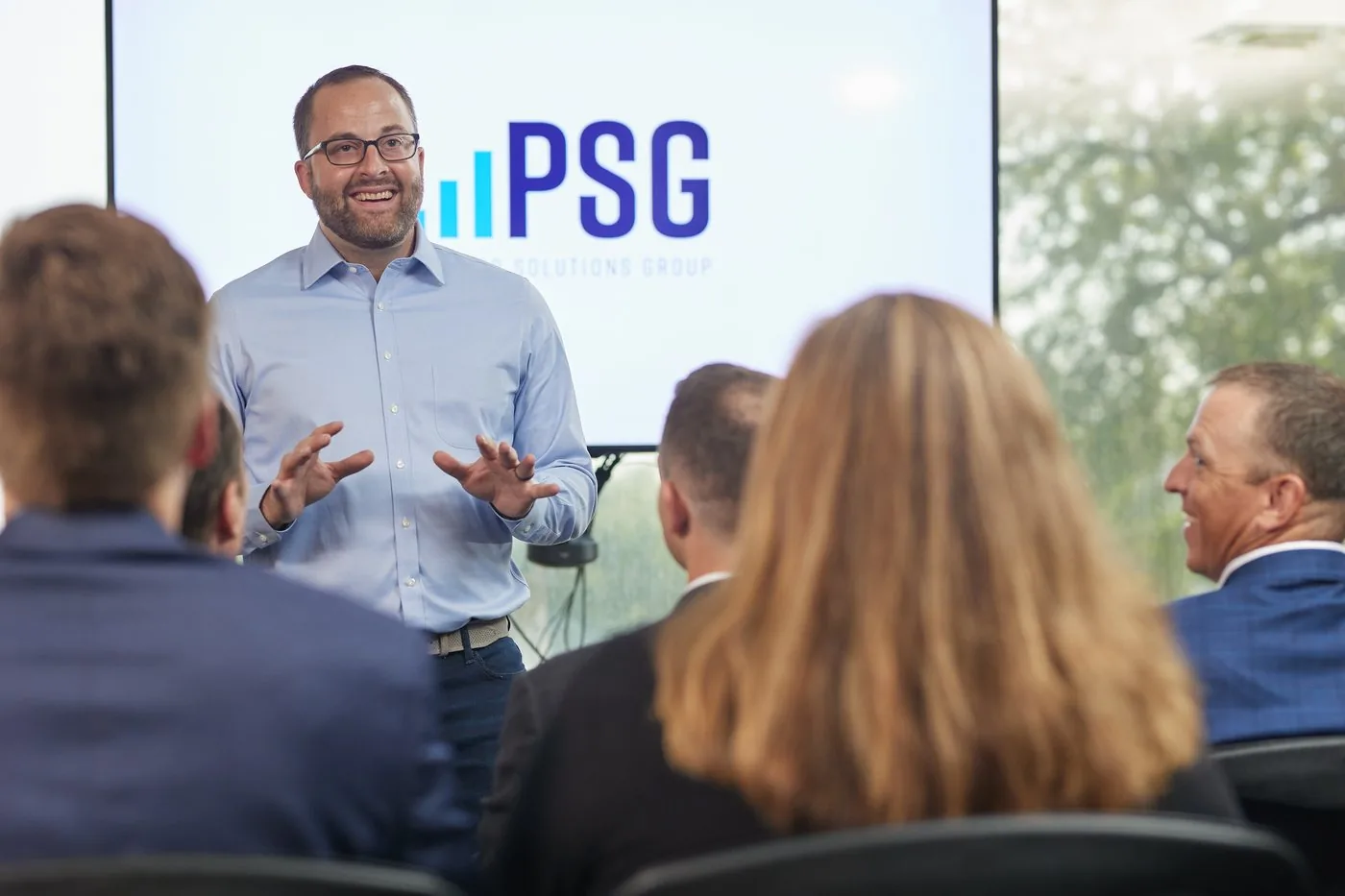 A Prenger Solutions Group consultant presenting to the team with the PSG screen behind them
