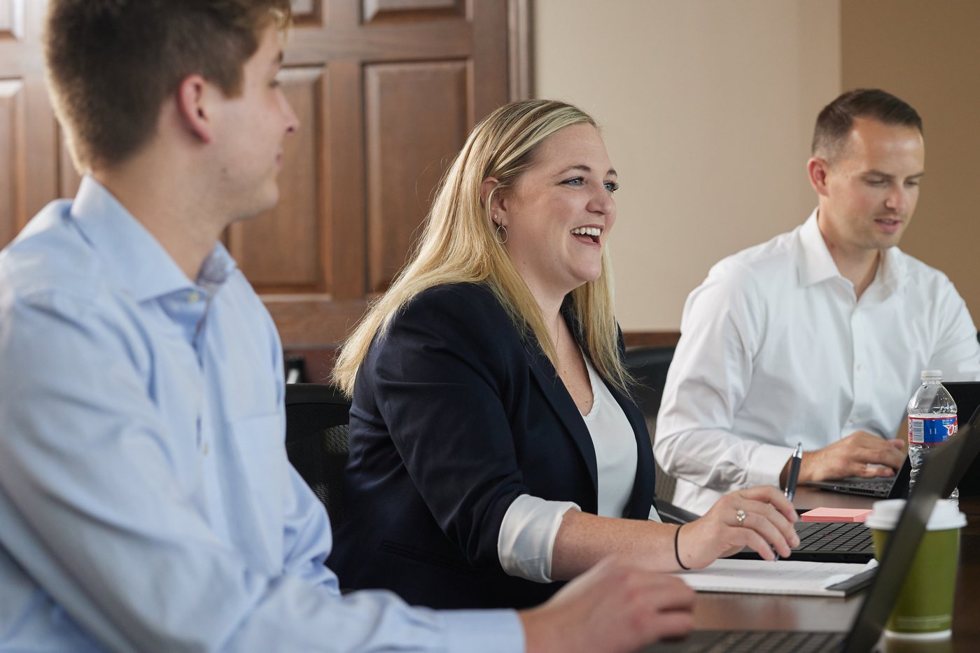 A smiling Prenger Solutions Group consultant reviewing donor emails on a laptop during a working session