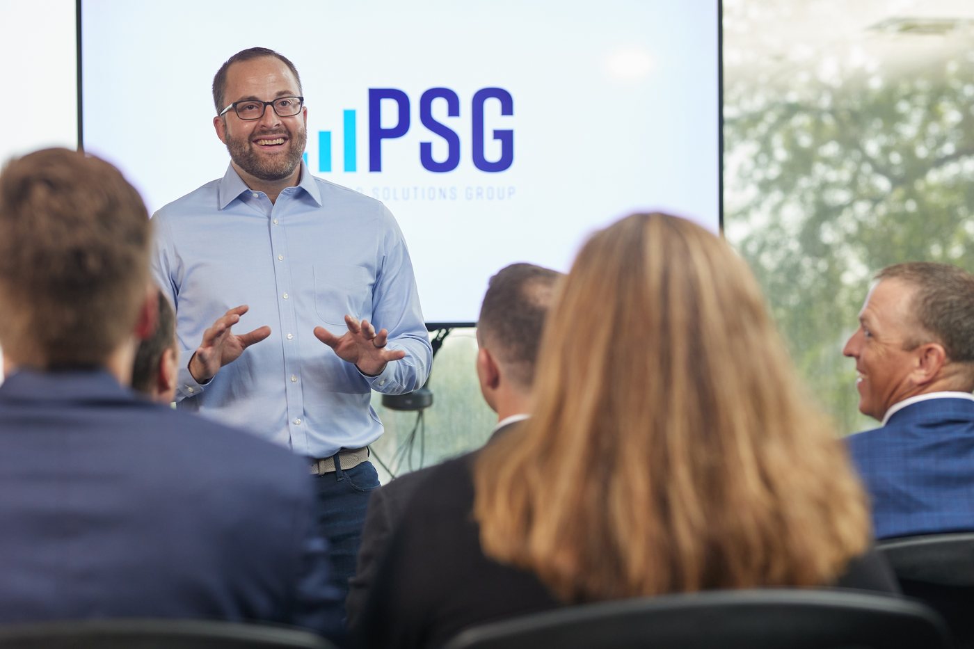 A Prenger Solutions Group consultant presenting to the team with the PSG screen behind them
